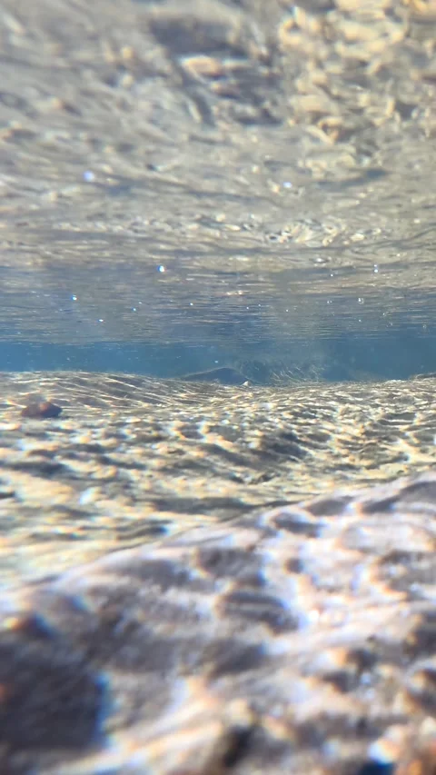 Underwater View of Sunlight Refracting on a Shallow River Bed Stock Footage 341910260