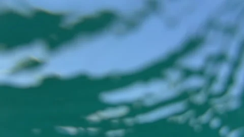 Underwater view of sunlit sky through gently moving ocean surface with soft blue Stock Footage 341408901