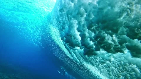 Underwater view of surfer dive under wave breaking over coral reef. Tahiti Stock Footage 208538275