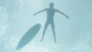 Underwater View Of Surfer Paddling Surfboard Stock Footage