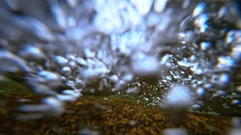 Underwater view of turbulent rushing stream water with air bubbles Stock Footage 334933416