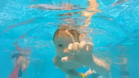 Underwater viewpoint of pool as boy dives and swims towards camera Video stock 78855314