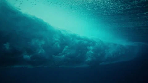 Underwater vortex barrel wave bubbles with fish near sparkling surface slow Stock Footage 333447164