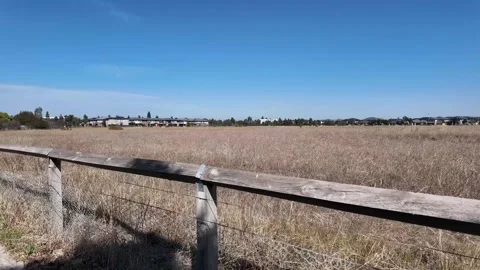 Undeveloped grassland behind fence in an outer suburb of Melbourne Australia. Stock Footage 305976766