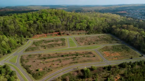Undeveloped subdivision layout with newly built roads winding through a cleared Stock Footage 323456025