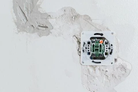 Undone AC power socket in wall. Repairs in the apartment. Stock Photos