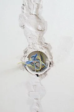 Undone AC power socket in wall. Repairs in the apartment. Stock Photos