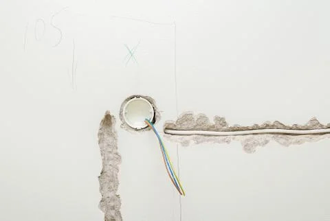 Undone AC power socket in wall. Repairs in the apartment. Stock Photos