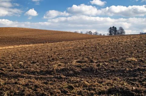 Undulating plowed field in early spring Stock Photos