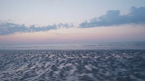 The Undulating Sandy Seashore at Dusk Under a Cloudy Sky Stock Footage 346689720