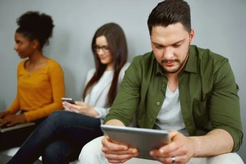 Unemployed young man sit in queue with other applicants wait for company work Stock Photos