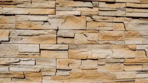 Uneven random brick background texture pattern. Close up of stone masonry. Stock Photos