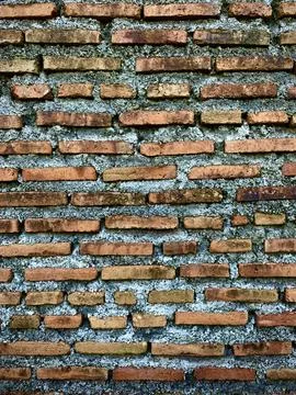 Uneven rough red brick wall background, old vintage brick wall and cement Stock Photos