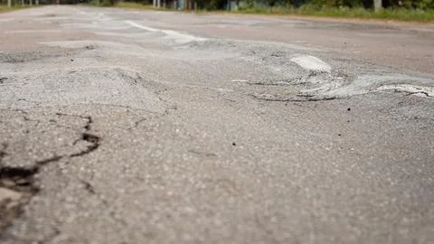 Uneven surface of asphalt road Stock Photos