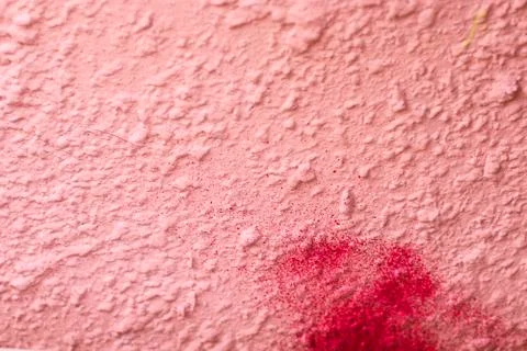 The uneven wall texture background was painted with pink paint and red spray Stock Photos