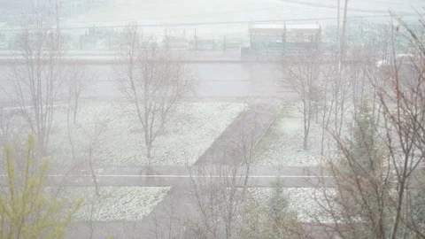 Unexpected snow in the spring. Strong blizzard in the spring in the city. Stock Footage 129949376