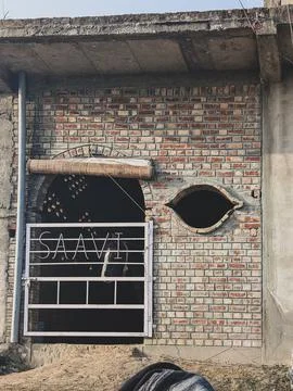 Unfinished brick house facade with arched doorway Stock Photos