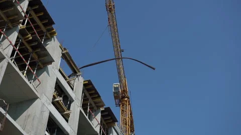 An unfinished building with a working construction crane Stock Footage 251711167