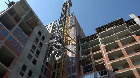 An unfinished building with a working construction crane Stock Footage 251711174