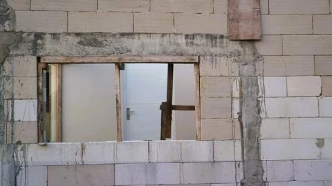 Unfinished concrete block wall with a rectangular window opening under construct Stock Photos