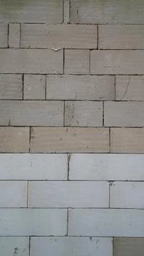 Unfinished concrete block wall with a rectangular pattern under construct Stock Photos