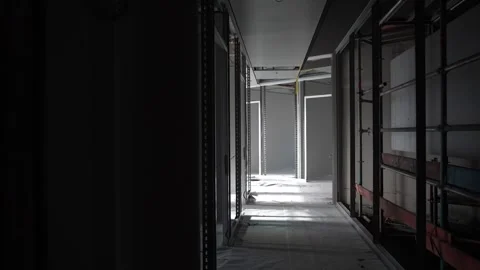 Unfinished corridor with drywall framing and light at end of hallway Stock Footage 332584230