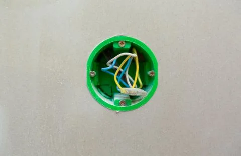 Unfinished electrical mains outlet socket with electrical wires installed in Stock Photos