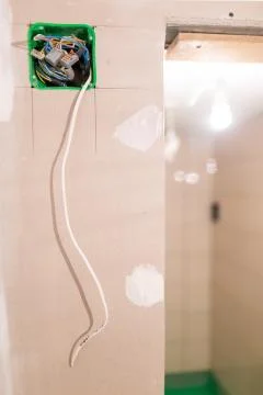 Unfinished electrical mains outlet socket with electrical wires installed in Stock Photos