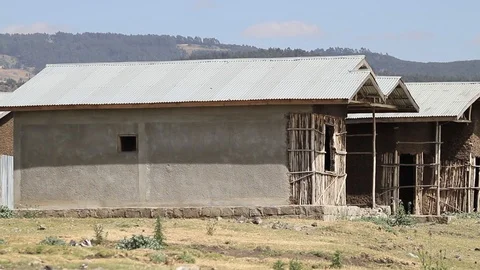 Unfinished mud homes side by side close up shot and raven flying Stock Footage 97105651