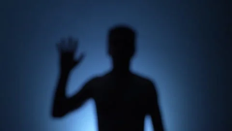 Unfocused backlit man do hello sign with his hand Stock Footage 278239163