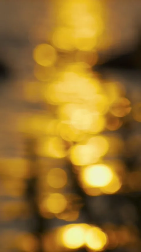 An unfocused image of sunlight on the waves of a lake or sea at sunset. Видео 336621122