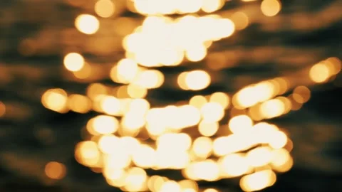 An unfocused image of sunlight on the waves of a lake, sea or ocean at sunset. Vidéo 337563479