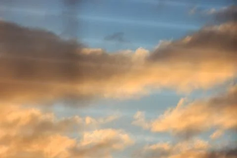Unfocused, multicolored clouds at dawn, view through the blinds. bright sky f Stock Photos