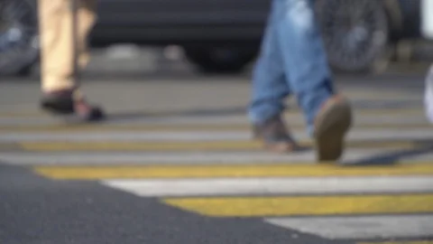 Unfocused view of elderly man walking with a cane through a pedestrian crossing Stock Footage 116390293