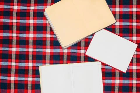 Unfolded notebooks with white sheets on a colored background in a cell Stock Photos
