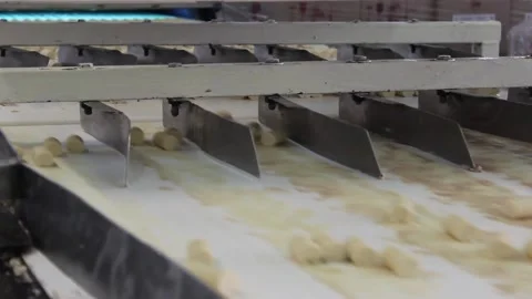 Unglazed candy bars move along a conveyor belt in a confectionery factory. Stock Footage 128643074