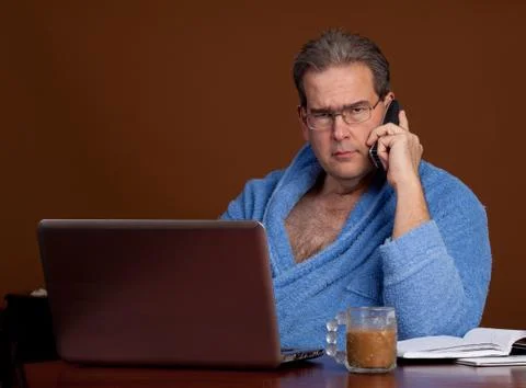 Unhappily working in a bathrobe Stock Photos