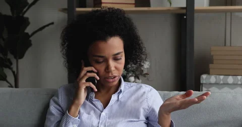 Unhappy african american young woman holding unpleasant cellphone call Stock Footage