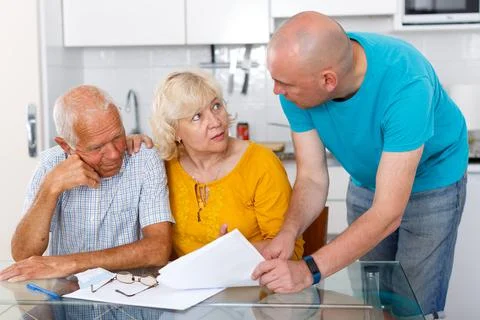 Unhappy aged couple signing financial agreement with social worker Stock Photos