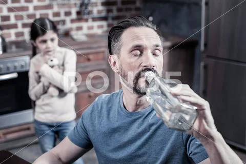 Unhappy cheerless man drinking vodka Stock Photos
