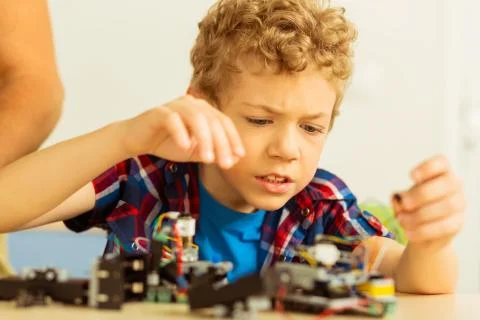Unhappy cute boy having problems with robot construction Stock Photos
