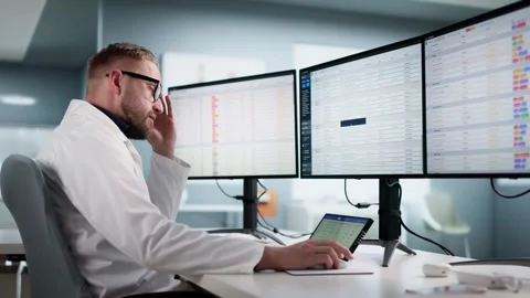 Unhappy Doctor Frustrated Using Boring Medical Spreadsheet Stock Footage 320765697
