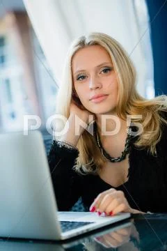 Unhappy female student tired of doing homework sitting at cafe with laptop Stock Photos