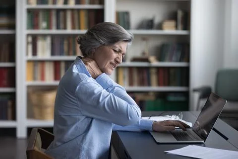Unhappy frustrated senior woman feeling strong neck ache Stock Photos