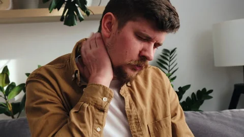 Unhappy guy hold hand on neck, suffering from neck pain, incorrect posture Stock Footage 236455257
