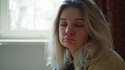 Unhappy ill young blonde woman sneezing allergy into paper napkin looking very Stock Footage 127195896