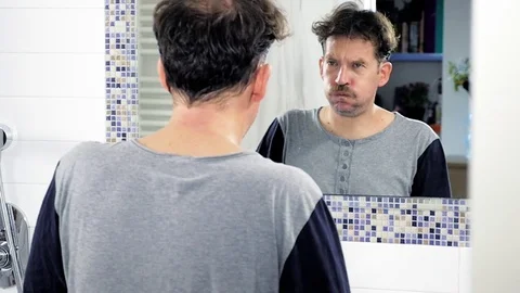 Unhappy man in front of mirror thinking tracking shot slow motion Stock Footage 82183131