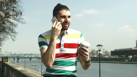 Unhappy man having a quarrel on cellphone while sitting on boulevards Stock Footage