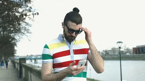 Unhappy man looks irritated while having problems with smartphone, steadycam sho Stock Footage