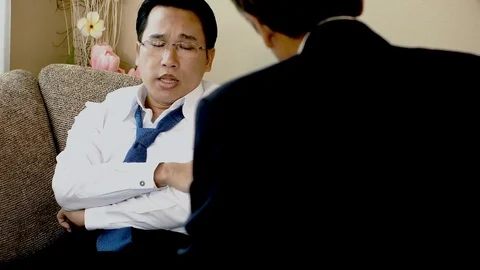 The unhappy man sitting on the sofa talking to the psychiatrist Stock Footage 83295780